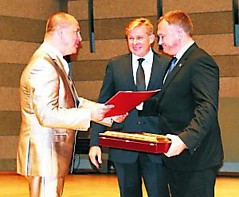 Lietuvos savivaldybių asocialcijos prezidentas Ričardas Malinauskas ir užsienio reikalų ministras Audronius Ažubalis įteikė Auksinę krivūlę Telšių rajono savivaldybės merui Valdemarui Ramšui. KŽ nuotr.